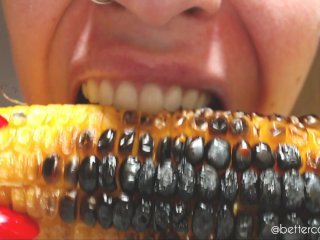 I bite and chew a delicious roasted corncob, a close-up of my sharp teeth