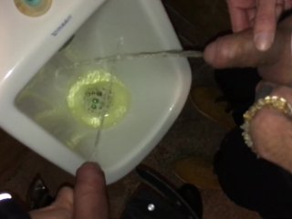 Boys piss and spit together at the urinal after some cocktails