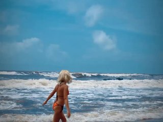 Tik Tok. Beach Voyeur looks on Blonde Teen enjoying Topless in the waves. 