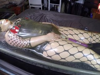 Miss Maskerade in latex vacuum bed wearing a silicone female mask as a rubber doll