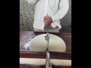 Young guy in a shirt masturbates thick dick by a mirror