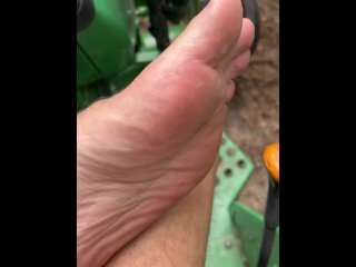 Dirty feet on tractor cutting wood