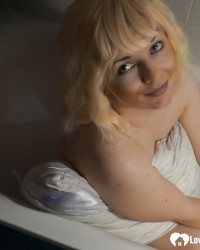 Blonde with big tits teasing in a bathtub photo