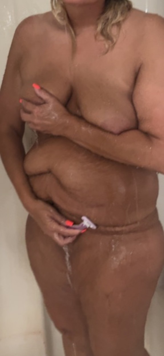 Sexy Milf shaving in the shower photo