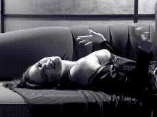 Pinup beauty Bobbi Starr laying on couch with her tits exposed gif