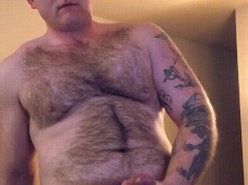 Handsome, stocky, hairy Richard strokes his hot cock and shoots a huge load gif