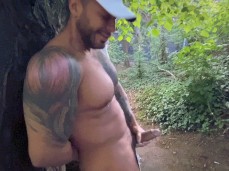 Leaning against a tree, a beefy muscle hunk was stroking his massive cock gif