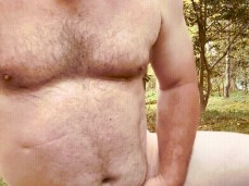 Horny daddy bear kneels buck naked in the garden, stroking his thick cock gif