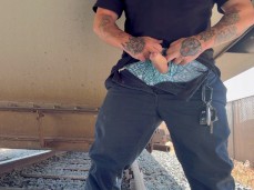 Horny railway worker strokes his big, thick, uncut cock under a train wagon gif