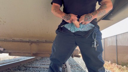 Horny railway worker strokes his big, thick, uncut cock under a train wagon