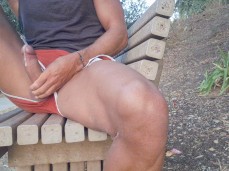 Fit guy strokes his big, uncut cock and cums har on a bench in public park gif
