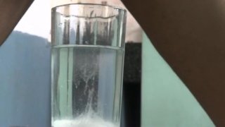 Chico cumming en un vaso de agua