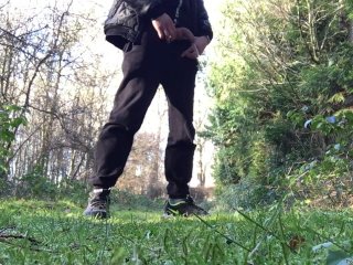 boy is urinating in the woods