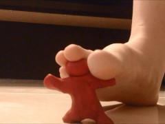 Girl crushing clay men with Barefeet