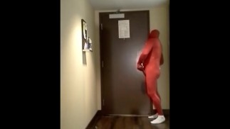 Красный морфокостюм у дверей гостиничного номера