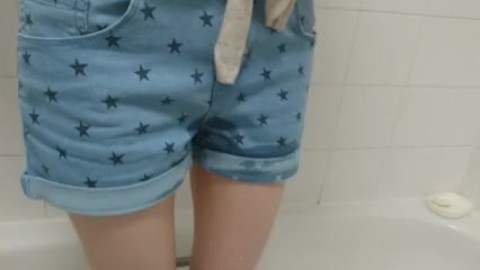 girl wets her denim shorts