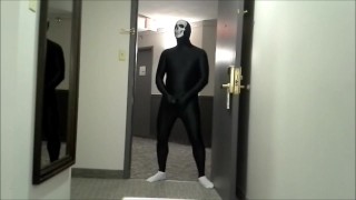skeleton faced white socked black morphman in front of hotel room