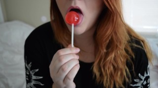 girl with glasses licks lollipop