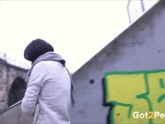 Frau pisst im Winter in einer Stadt