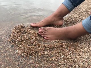 Ebony teen feet at the shore gets covered in sand.