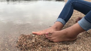 Ebony teen feet at the shore gets covered in sand.