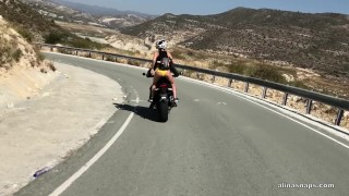 Seksowna motocyklistka robi sobie dobrze podczas jazdy na motorze