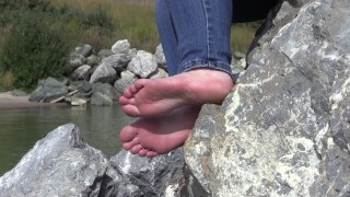 i piedi di una signora matura sulle pietre