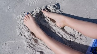 Песчаные ноги подростка на пляже