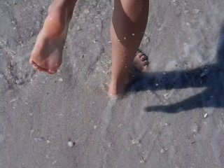 Wholesome teen getting her feet wet at the muddy beach