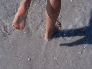 Wholesome teen getting her feet wet at the muddy beach