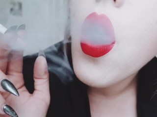 甘美な赤い唇のクローズアップ喫煙タバコを持つ愛人