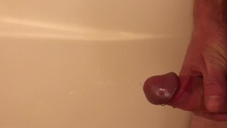 Guy pisses in the tub, then jerks himself off until he cums