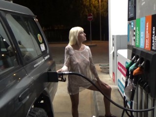 Blonde Em Um Vestido Transparente Enche o Carro no Posto De Gasolina