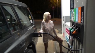 Blondynka W Przezroczystej Sukience Wypełnia Samochód Na Stacji Benzynowej