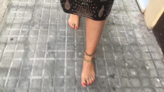 젊은 여성 히피가 공공 거리에서 맨발로 걷고 있다