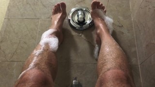 Pies y piernas de jock jabonoso en la bañera