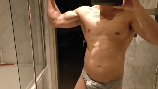 Толстый папа с твердым животом разминает свои твердые мышцы, чтобы обнажить шесть пакетов