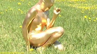 ebony babe in skintight golden spandex catsuit posing outdoor