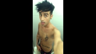 Ragazzo tatuato sta pisciando nel bagno pieno di piscio del parco acquatico