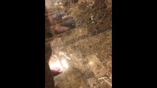 Reno, reflejo de la puerta de la ducha del hotel acariciando la polla blanca