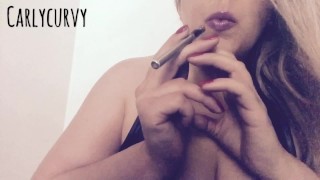 Blonde Carlycurvy vaping and playing in a short leather dress