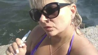 Rauchfetisch am Strand. Große Brüste aus nächster Nähe