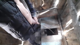 Russian guy pisses in a rustic toilet