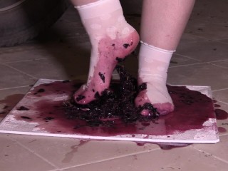 白色袜子丰满的双腿无情地践踏了葡萄。 粉碎