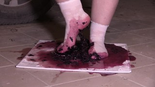 Plump legs in white socks mercilessly trample grapes. Crush fetish