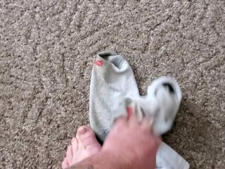 Takes sweaty, dirty work socks off and shows feet!