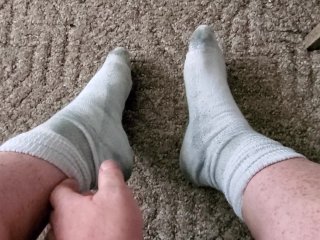 Takes sweaty, dirty work socks off and shows feet!