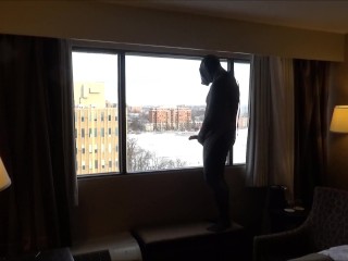 Возбужденный парень в мокром костюме в маске заглядывает в окно гостиничного номера