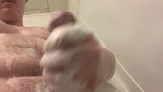 허스키 남자가 샤워실에서 자지를 문지른다.