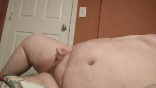 Hombre gordo masturbándose su pequeña polla con loción